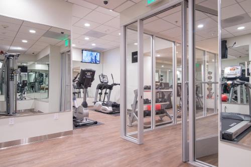 a gym with treadmills and ellipticals and mirrors at Miyako Hotel Los Angeles in Los Angeles
