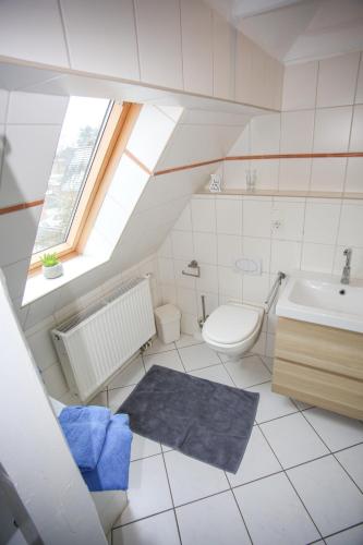 a white bathroom with a sink and a toilet at Ferienwohnung Wieben in Sankt Peter-Ording