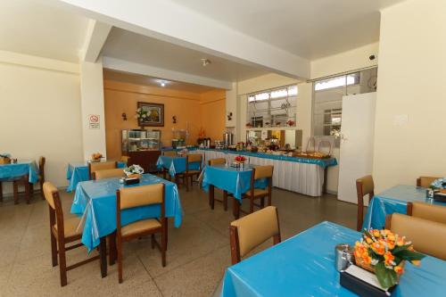 uma sala de jantar com mesas e cadeiras azuis em Guanabara Hotel Centro Belo Horizonte em Belo Horizonte