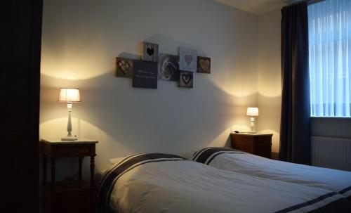 a bedroom with a bed and two lamps and a window at Aan 't kapelke in Valkenburg