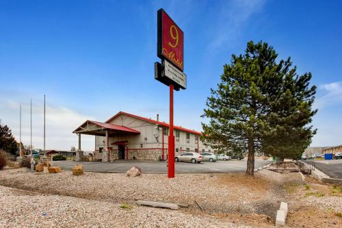 a gas station with a sign in front of it at Motel 9 in Fort Collins