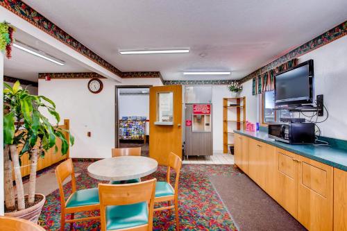 a room with a table and chairs and a tv at Motel 9 in Fort Collins
