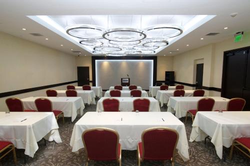 a room with white tables and chairs and a projection screen at Miyako Hotel Los Angeles in Los Angeles