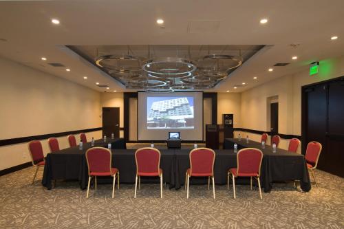 a conference room with a table and chairs and a screen at Miyako Hotel Los Angeles in Los Angeles