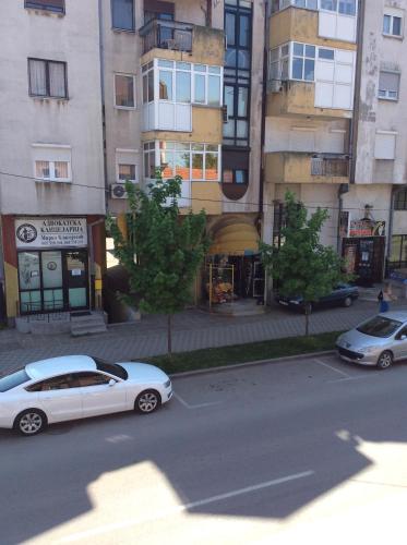 a white car parked in a parking lot in front of buildings at Apartman br 4 in Bijeljina