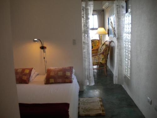 1 dormitorio con 1 cama y 1 habitación con ventana en Plumita Pacifica, en Playa Junquillal