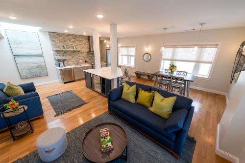 a living room with two blue couches and a table at The Newport Lofts - 364 Thames Street in Newport