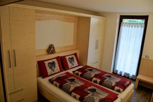 a bedroom with two beds and a window at Enrosadira in Molveno