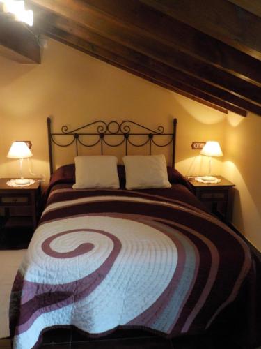 una camera con un grande letto con due lampade di Apartamentos Rurales La Husteriza a Ruenes