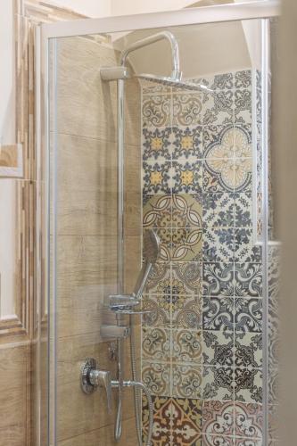 a shower with a glass door and a tile wall at Il Tempo Ritrovato - Locazione ad uso turistico in Palermo