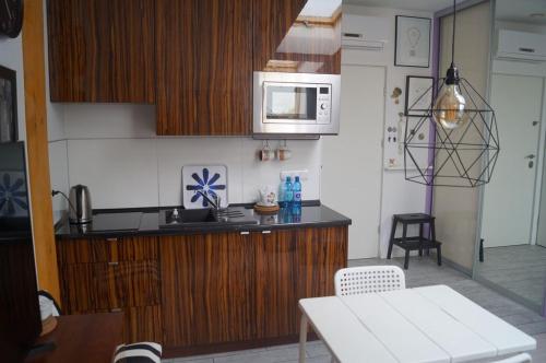 una cucina con piano di lavoro e forno a microonde di Apartament Ariańska a Cracovia