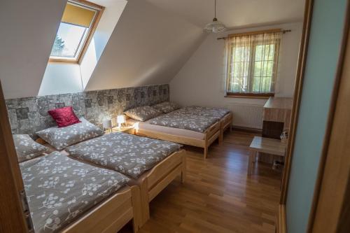 a attic room with two beds and a couch at Vila Veronika in Lednice