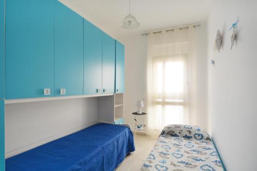 a bedroom with blue cabinets and a bed and a chair at Borgata Mazzarelli in Marina di Ragusa