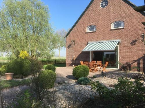 a brick building with a table and chairs in front of it at B&B De Kaagse Koe in Huigsloot