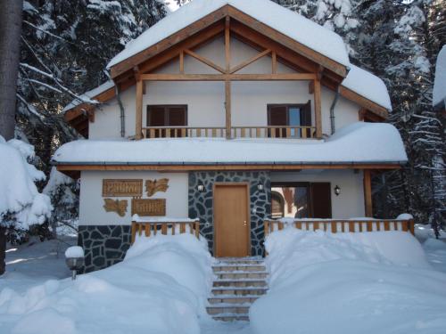 a cabin in the woods with snow on the ground at Saint George Holiday Village in Borovets