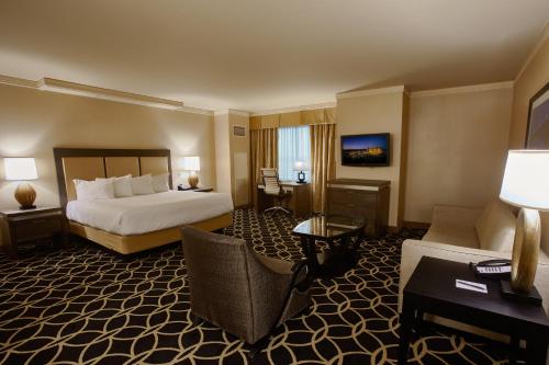 a hotel room with a bed and a living room at Hollywood Casino St. Louis in Maryland Heights