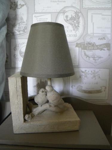 a lamp with two birds sitting on a table at Gîte et Chambres d'hôtes du Domaine du Val Bruant in Arc-en-Barrois