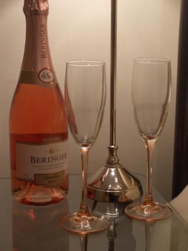 two champagne glasses and a bottle on a table at Big Sky Guest House- ROOM ONLY in Whitby