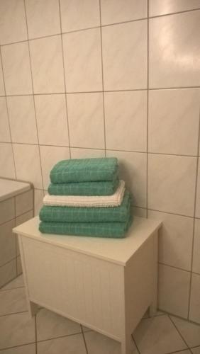 ライプツィヒにあるGästewohnungen Engelsdorfのバスルームの棚に座った緑のタオル3枚