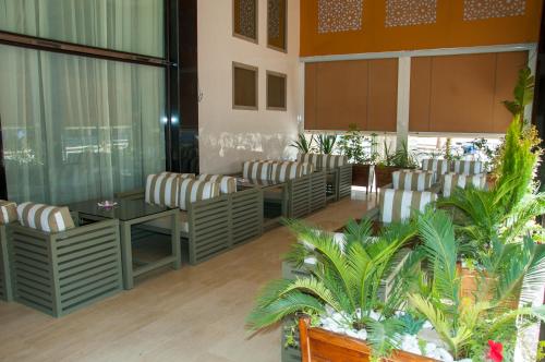 a waiting room with chairs and tables and plants at Sania Hotel in Sidi Bennour
