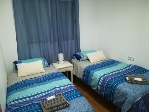 Formentera de SeguraにあるFormentera Centroのベッドルーム1室(ベッド2台、スーツケース1つ付)