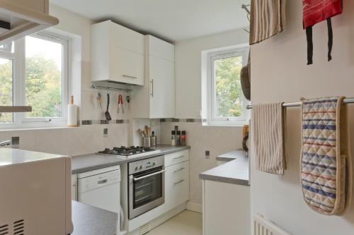 una cucina con armadi bianchi e piano cottura di Poplar House Serviced Apartments a York