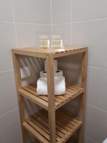a wooden shelf in a bathroom with towels at Cabanas Family Apartment in Cabanas de Tavira