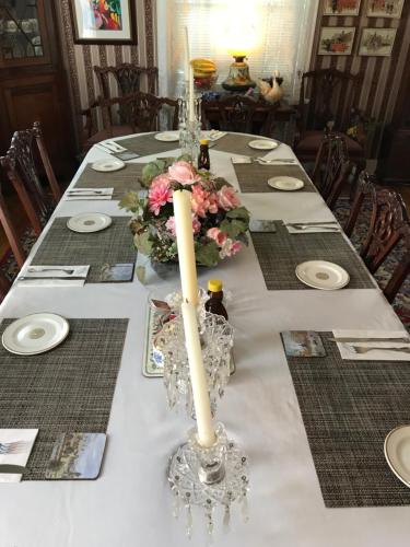 a long table with a white table cloth with a candle at Rose Manor Bed & Breakfast in New Orleans