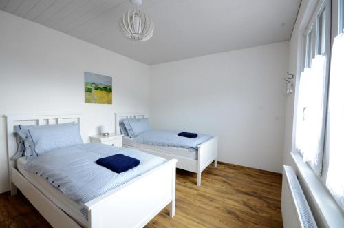 ein weißes Schlafzimmer mit 2 Betten und einem Fenster in der Unterkunft Interlaken Central 3 in Interlaken