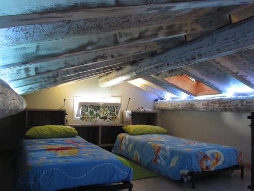 two beds in a room with wooden ceilings at Le Stagioni di Bacco in Monsummano