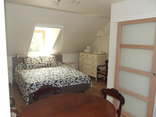 a bedroom with a bed and a window and a table at Au Bonheur Frontalier in Steenvoorde
