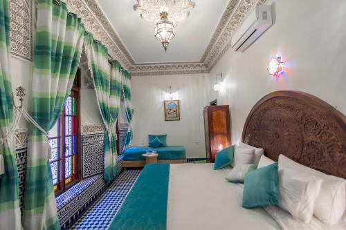 a bedroom with a bed and a chandelier at Dar Fes Tresor in Fez