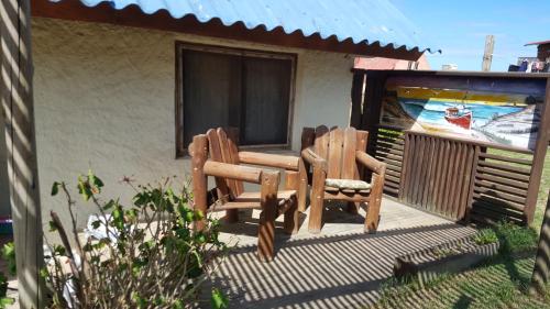 two chairs and a table on a patio at Maxival Cabañas in Punta Del Diablo