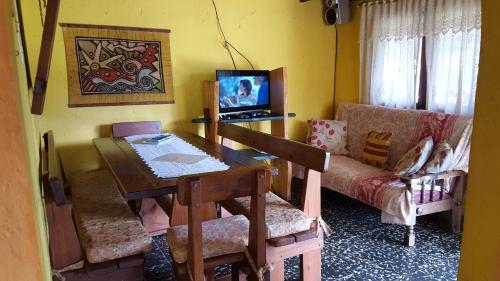 sala de estar con mesa y sofá en Maxival Cabañas, en Punta del Diablo