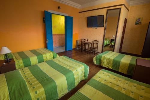 a hotel room with two beds and a television at Hostal Los Balcones de Moral y Santa Catalina in Arequipa