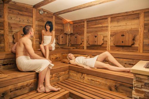 a man and a woman sitting in a sauna at Wohlfühlhotel Bercher in Waldshut-Tiengen