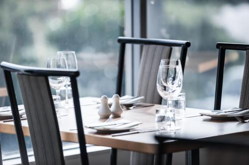 a wooden table with wine glasses and napkins on it at Bay Plaza Hotel in Wellington