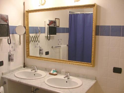 a bathroom with two sinks and a large mirror at Hotel Relais Modica in Modica