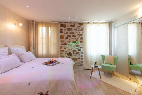 a bedroom with a large white bed and a green chair at Aby in Cannes