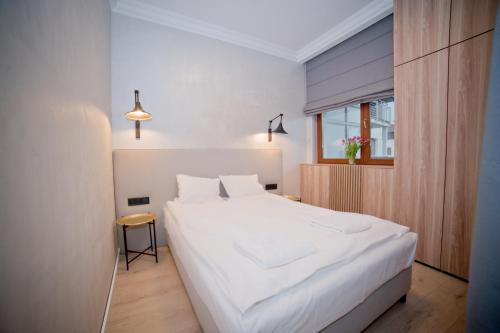 A bed or beds in a room at Lucy Apartment Neptun Park - Hav Aparts
