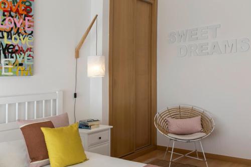 a bedroom with a bed and a chair and a table at Silver Coast - Casa do Oceano in Foz do Arelho