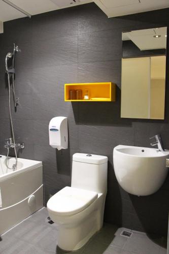 a bathroom with a white toilet and a sink at Horizon Inn in Taipei