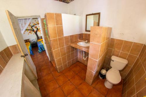 a bathroom with a toilet and a sink at Hotel Cafe del Sol in Monterrico
