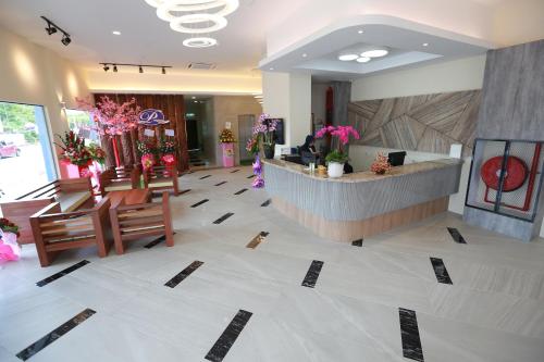 a lobby of a hotel with a reception desk and flowers at Pantai Regal Boutique Hotel in Kuantan