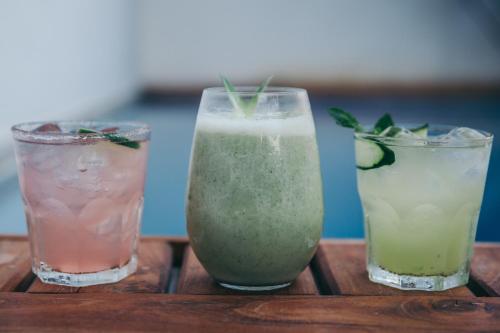 drie drankjes staan op een houten tafel bij Teetotum hotel in Tulum