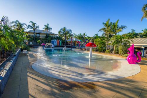 a pool with a water park with a pink dinosaur at Ingenia Holidays Wairo Beach in Lake Tabourie