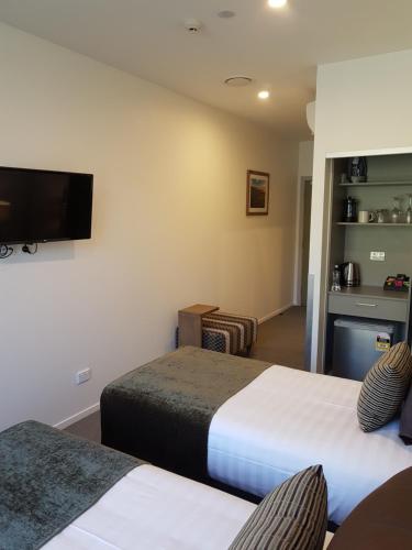 a hotel room with two beds and a flat screen tv at Wyndham Garden Remarkables Park Queenstown in Queenstown