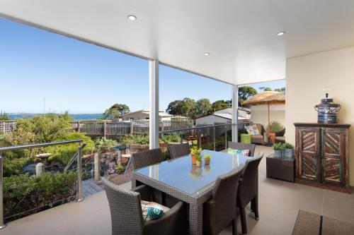 a dining room with a table and chairs on a balcony at Luna Blu - Luxury B&B in Rhyll