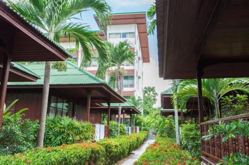 a walkway through a building with palm trees and flowers at Lamai Coconut Beach Resort in Lamai