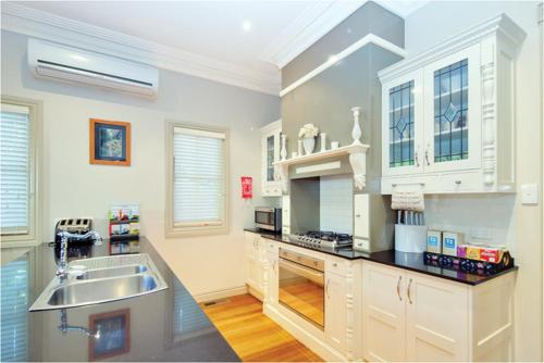 a large kitchen with a sink and a counter top at Brantwood Cottage Luxury Accommodation in Blackheath